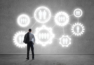 İş adamının çizilmiş dişli mekanizmasıyla duvara baktığı arka plan