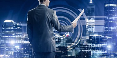 Sanal panel arayüzüne karşı iş adamının arka görünümü belgeleri elinde tutuyor