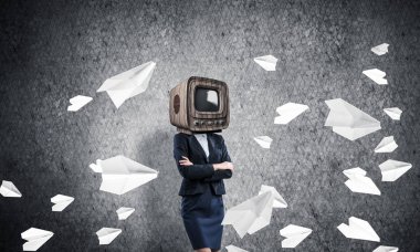 Arka plan üzerinde duran kağıt uçak uçan arasında ve gri karanlık Duvar ile iş kadını kıyafetli kafa silah tutmak yerine eski Tv ile geçti.