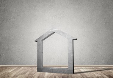 Ev taşı figürü, boş beton odadaki gayrimenkullerin sembolü.