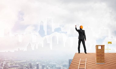 Mühendis, evinin çatısına geri döndü ve şehri çiziyor. Karışık ortam