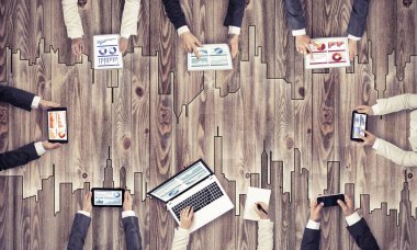 Ellerinde cihazlar bulunan bir grup insan, iletişim ve ağın sembolü olarak birlikte çalışıyor.