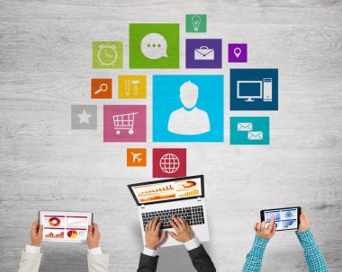 Ellerinde cihazlar bulunan üç kişilik bir grup iletişim ve ağ oluşturma sembolü olarak birlikte çalışıyor.