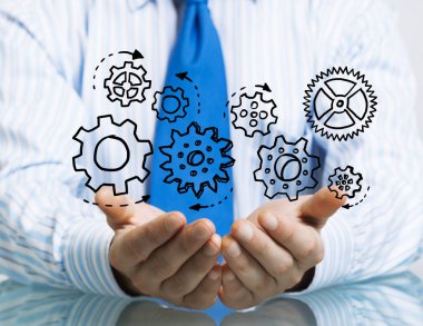 Masada oturan ve dişli mekanizması avuç içi gösterilen işadamı yakın çekim