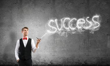 Akıllı-rahat, kendinden emin ve genç işadamı yatay atış yasaktır boru gri karanlık duvar ve duman arka plan üzerinde yapılan başarı kelime karşı dururken giymek.