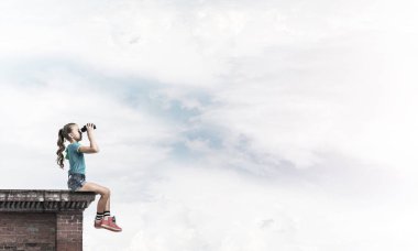 Dürbünle bakan, okul çağındaki sevimli kız çatıyı inşa ediyor.