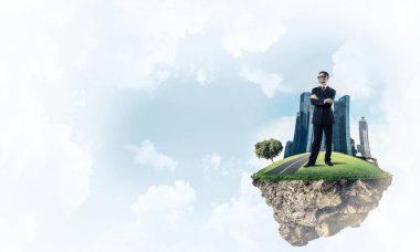 Mavi gök yeşil yüzen ada üzerinde duran zarif emin iş adamı