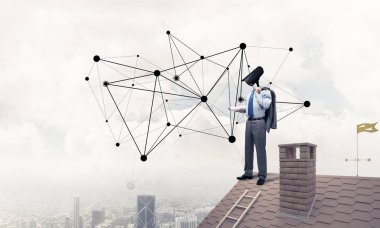 Evin çatısında baş durmak yerine kamerayla zum yapan yüzü olmayan bir iş adamı.