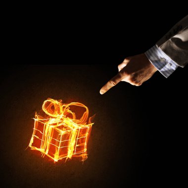 Parlayan yangın hediye kutusu simgesinin koyu arka plan üzerine gösteren işadamı ele