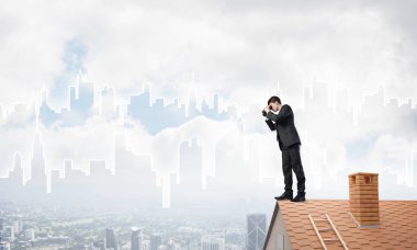 Genç işadamı dürbünüyle şehir manzarasını izliyor. Karışık ortam