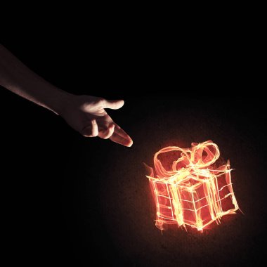 Parlayan yangın hediye kutusu simgesini avuç içi koyu arka plan