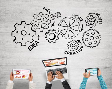 Ellerinde cihazlar bulunan üç kişilik bir grup iletişim ve ağ oluşturma sembolü olarak birlikte çalışıyor.