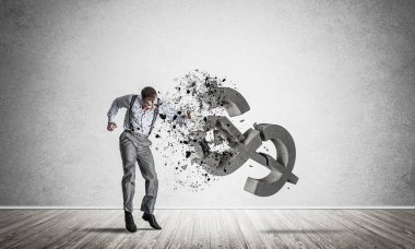 Boş odadaki öfkeli genç işadamı yumruklanmış dolar sembolüyle kaza yapıyor.
