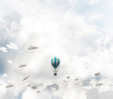 Kağıt uçakların arasında ve mavi bulutlu gökyüzünde renkli bir aerostat uçuyor. 3B görüntüleme.