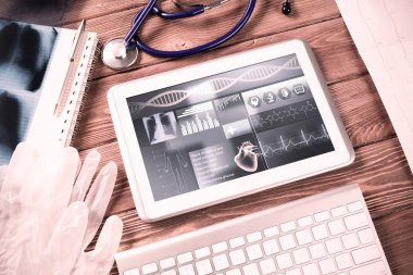 Beyaz tablet bilgisayar ve doktor aletleri ahşap masada.