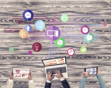 Ellerinde cihazlar bulunan üç kişilik bir grup iletişim ve ağ oluşturma sembolü olarak birlikte çalışıyor.