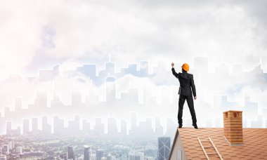 Mühendis, evinin çatısına geri döndü ve şehri çiziyor. Karışık ortam