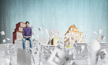 Belgeleri arka plan üzerinde kabataslak cityscape manzaralı uçan arasında casual giyim oturuşta çekici bir adam. Karışık teknik.