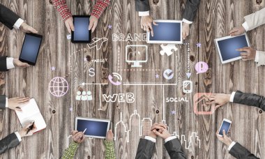 Ellerinde cihazlar bulunan bir grup insan, iletişim ve ağın sembolü olarak birlikte çalışıyor.