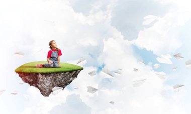 Gökyüzünde yüzen bir adada oturan tatlı, gülümseyen bir kız.