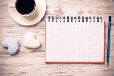 Kahve fincanı not defteri kalem ve ahşap yüzeyde iki kalp