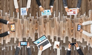 Ellerinde cihazlar bulunan bir grup insan, iletişim ve ağın sembolü olarak birlikte çalışıyor.