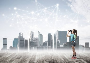 Şirin kız ahşap bir zeminde duruyor ve dürbünle izliyor.