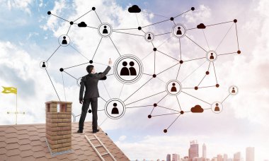 Delikanlı çatıda dikiliyor ve bağlantı hatları çiziyor. Karışık ortam