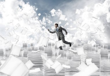 Takım elbise ile telefonu elinde kitap Clear sky ile arka plan üzerinde uçan arasında çalışan iş adamı. Karışık teknik.