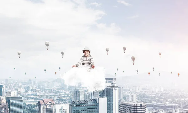 若い男の子の目を維持が閉じられ 都市景観ビューと空気にクラウドに瞑想と背景に気球を飛行しながら集中して見て — ストック写真