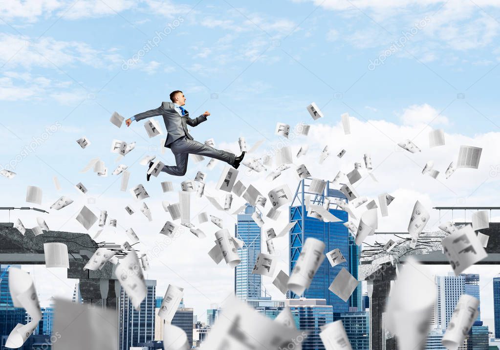Businessman jumping over gap with flying paper documents in concrete bridge as symbol of overcoming challenges. Cloudly skyscape on background. 3D rendering.