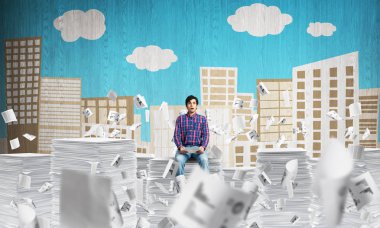 Belgeleri arka plan üzerinde kabataslak cityscape manzaralı uçan arasında casual giyim oturuşta çekici bir adam. Karışık teknik.