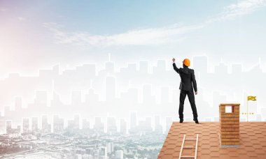 Mühendis, evinin çatısına geri döndü ve şehri çiziyor. Karışık ortam