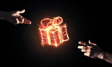 Parlayan yangın hediye kutusu simgesini avuç içi koyu arka plan