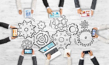 Ellerinde cihazlar bulunan bir grup insan, iletişim ve ağın sembolü olarak birlikte çalışıyor.