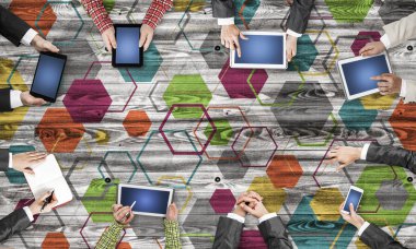 Ellerinde cihazlar bulunan bir grup insan, iletişim ve ağın sembolü olarak birlikte çalışıyor.