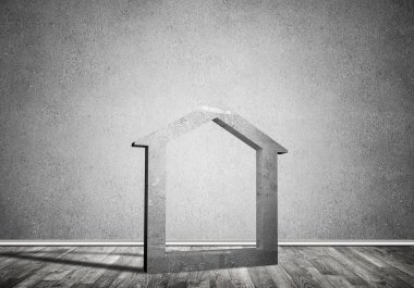 Ev taşı figürü, boş beton odadaki gayrimenkullerin sembolü.