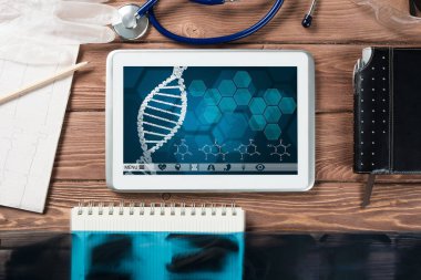 Beyaz tablet bilgisayar ve doktor aletleri ahşap masada.