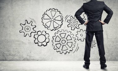 İş adamının çizilmiş dişli mekanizmasıyla duvara baktığı arka plan
