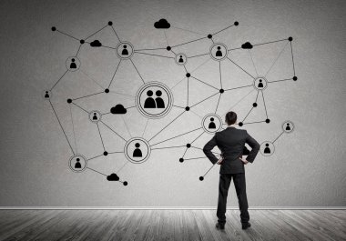 Arkadan görünüşü çizilmiş sosyal bağlantı kavramı ile duvara bakarak işadamı