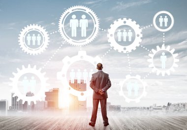 Modern şehir manzarası ve vites bağlantısı fikrine bakan işadamlarının arka planı