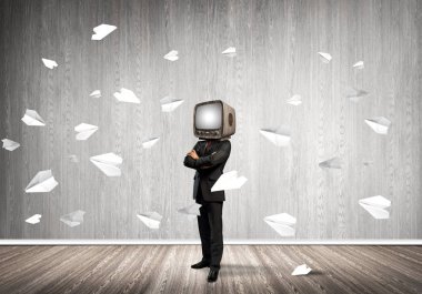 Kağıt uçaklar ile gri karanlık duvar boş oda içinde arka planda uçan arasında dururken kafasına silah tutmak yerine eski Tv ile takım elbiseli işadamı geçti.