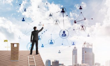 Delikanlı çatıda dikiliyor ve bağlantı hatları çiziyor. Karışık ortam