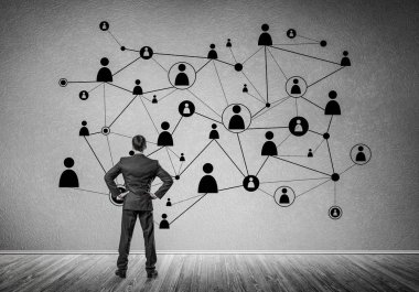 Arkadan görünüşü çizilmiş sosyal bağlantı kavramı ile duvara bakarak işadamı