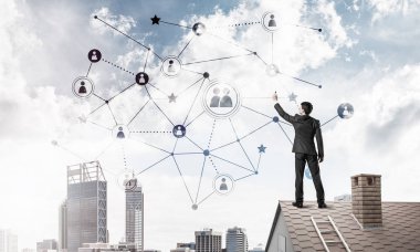 Delikanlı çatıda dikiliyor ve bağlantı hatları çiziyor. Karışık ortam