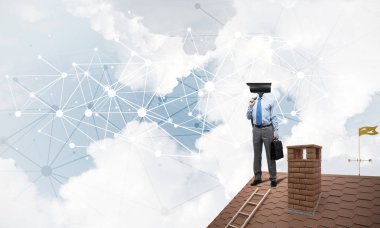 Evin çatısında baş durmak yerine kamerayla zum yapan yüzü olmayan bir iş adamı.