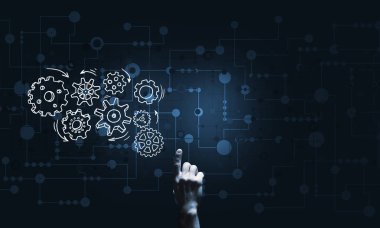 İş adamının eli dişli mekanizmasını işaret ediyor.