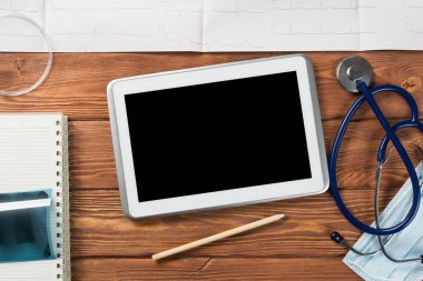 Tablet ve tıbbi öğeler ahşap masa üzerinde yüksek açı çekim