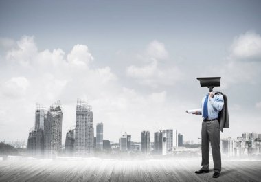 Şehir planına kafa atmak yerine kamerayla zum yapan yüzsüz bir iş adamı.