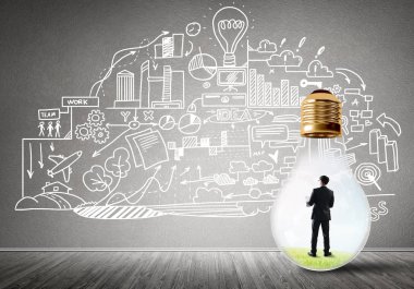 Boş beton odada ampulün içindeki iş adamı ve duvardaki çizimler